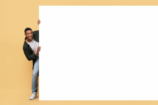 istock Excited african american guy posing next to advertising board 2010725603