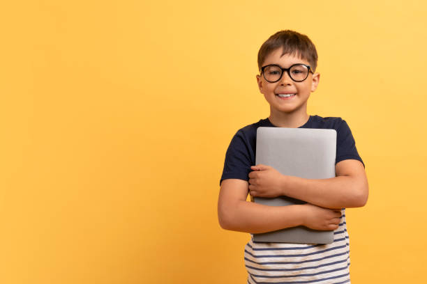 istock Cheerful guy school aged boy embracing computer laptop 2010737750