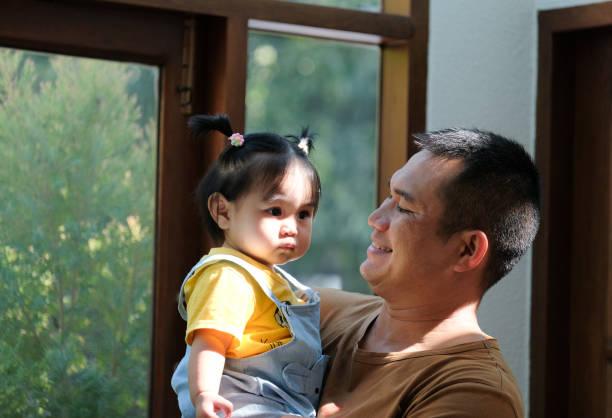 istock A father smiles at his daughter in his arms. 2010744714
