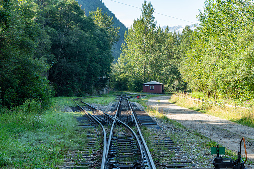 railroad tracks amidst snowcapped mountains against clear sky