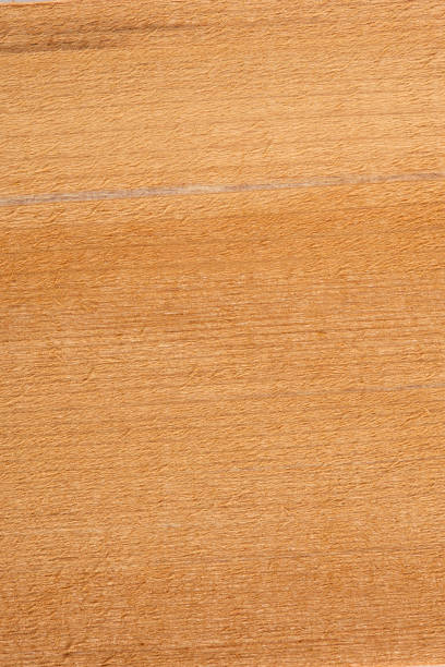 Weathered and scratched rustic wooden board.High angle view of a flat textured wooden board backgrounds. It has a beautiful nature and abstractive pattern. A close-up studio shooting shows details and lots of wood grain on the wood table. The piece of wood at the surface of the table also appears rich wooden material on it. The wood is dark brown color with darker brown lines and pattern on the bottom. Flat lay style. Its high-resolution textured quality.The close-up gives a direct view on the table, showing cracks and knotholes in the wood.
