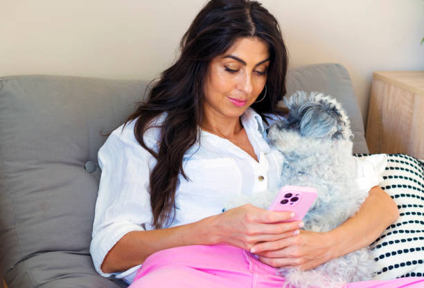 istock Smiling Woman using her phone at home 2010769407
