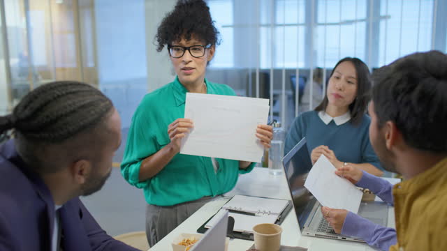 Woman talking in a meeting with her four younger colleagues