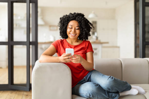 istock Mobile Communication. Beautiful young black female using smartphone at home 2010781634