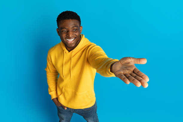 istock Happy millennial black guy holding something on his palm 2010805387