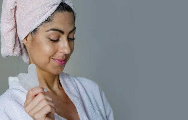 istock Beautiful Woman using  Gua Sha stone for face massage 2010812203