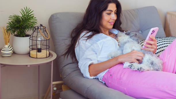 istock Smiling Woman using her phone at home 2010813900