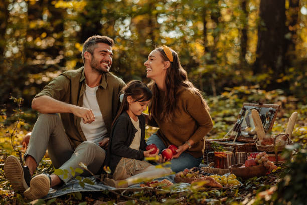 엄마, 아빠, 딸이 담요 위에 앉아 사과를 들고 숲에서 웃고 있습니다 - child vegetable squash corn 뉴스 사진 이미지