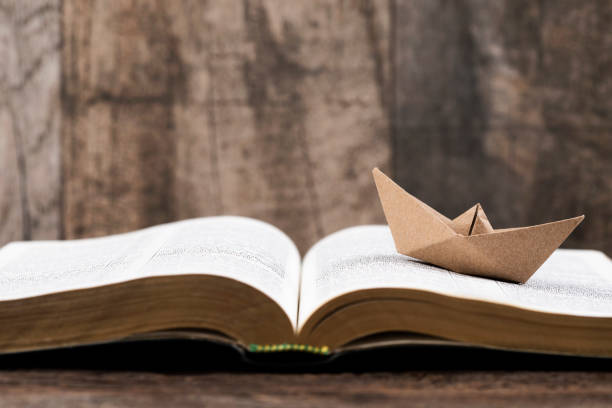 istock Open book and paper boat 2010832786