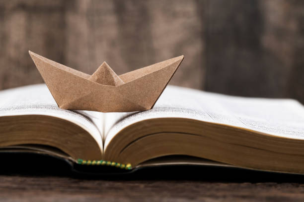 istock Open book and paper boat 2010833811