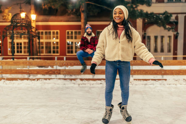 istock Cheerful woman ice skating on date 2010841752