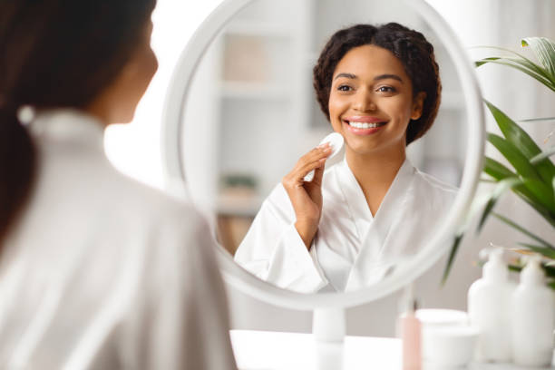 istock Beauty Routine. Smiling Black Woman Using Cotton Pad For Cleansing Face 2010866243