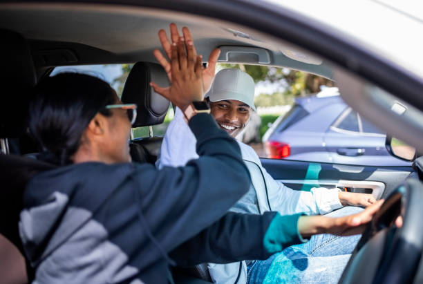 istock Cheerful young Indian learner driver giving high five to driving instructor in car 2010867251
