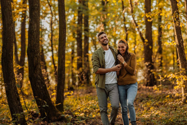 istock Happy couple hugging and walking in the forest 2010871113