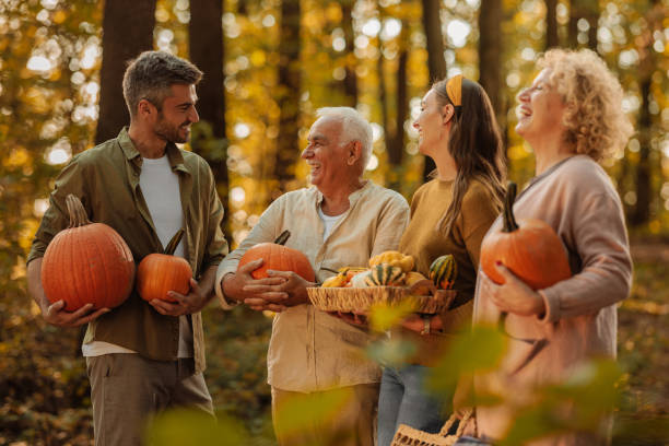 istock Family standing and laughing with pumpkins 2010877588