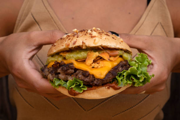 istock A woman holding a delicious gourmet burger 2010884501
