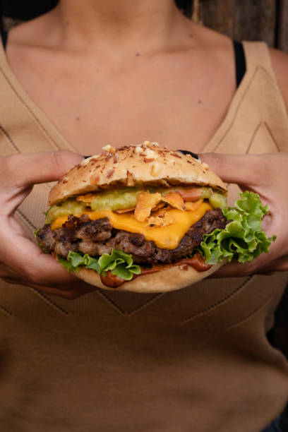 istock A woman holding a delicious gourmet burger 2010884502