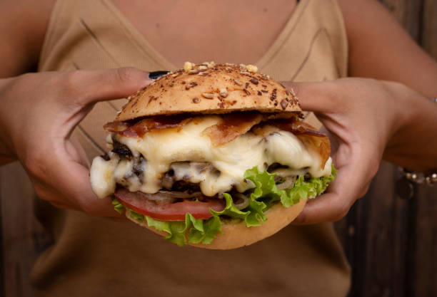 istock A woman holding a delicious gourmet burger 2010885053