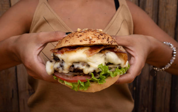 istock A woman holding a delicious gourmet burger 2010885564
