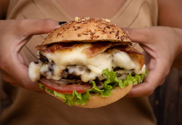 istock A woman holding a delicious gourmet burger 2010885582