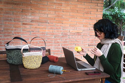 Mature woman working from home for her online store of handmade bags