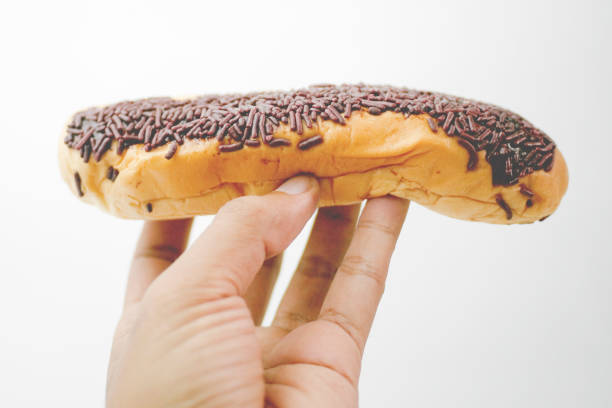 istock Close up hand holding chocolate bread isolated on white background 2010889548