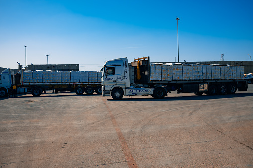 Kerem Shalom, Israel – January 10, 2024: A truck loaded with humanitarian aid at the Kerem Shalom border crossing between Israel and Gaza under a clear blue sky.