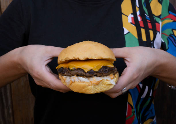 istock Woman holding a delicious cheeseburger 2010930704