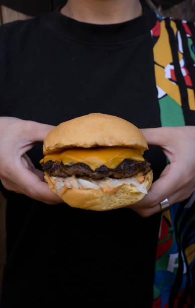 istock Woman holding a delicious cheeseburger 2010933313