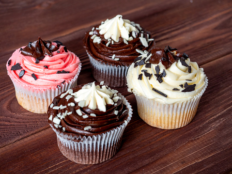 a set of delicious and sweet chocolate cupcakes on a wooden background. High-calorie dessert, selective focus