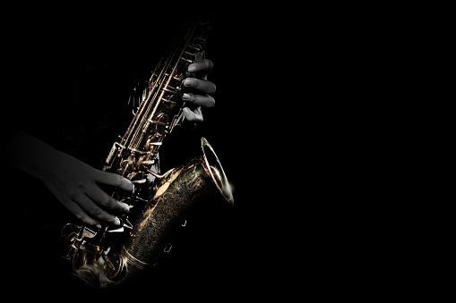 Saxophone player. Saxophonist playing jazz music instrument. Sax player hands