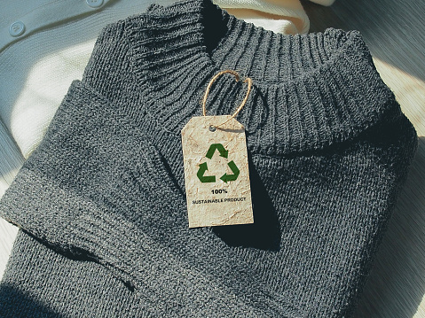 Sustainable Product concept, Renewable icon on tag of knitted sweater. Zero waste, Environmental, social, and corporate governance
