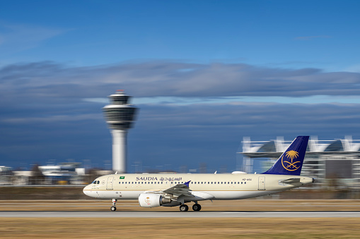 Munich, Germany - February 14. 2024 : Saudi Arabian Airlines Airbus A320-214 with the aircraft registration HZ-ASC is starting on the southern runway 26L of the Munich airport MUC EDDM