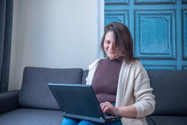istock Mature cheerful woman working on her laptop from home. Remote workplace. 2010999945
