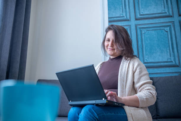 istock Mature cheerful woman working on her laptop from home. Remote workplace. 2011000453