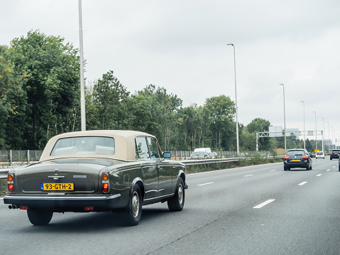 The Netherlands - Aug 19, 2018: Luxury beautiful vintage Rolls-Royce Silver Wraith II driving on Dutch highway - safety classic driving