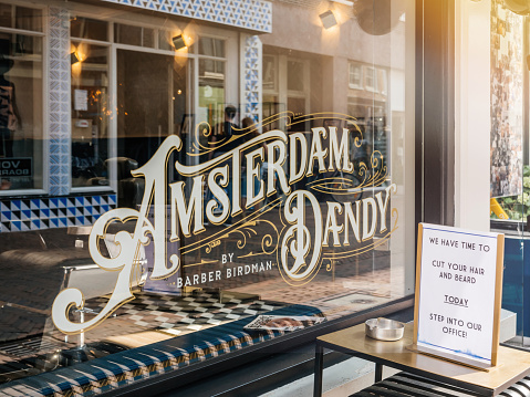 Haarlem, Netherlands - Aug 21, 2018: View from the street of vintage inscription Amsterdam Dandy by Barber birdman on the main street in Dutch city