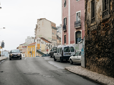Lisbon, Portugal - Feb 9, 2018: Portuguese street view in central part of the capital with tiny street and Toyota car driving on the road