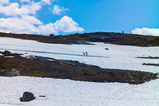 Jotunheimen National Park, Norway, Jun 25, 2023:  Cross-country skiers ski the slopes at the popular park off of the Sognefjellsveien route, is the highest mountain pass road in Northern Europe.