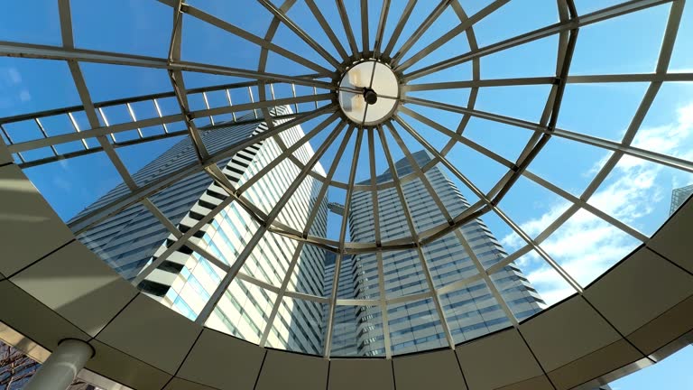 Skyward view of a modern glass dome structure with clear blue sky, architectural elegance