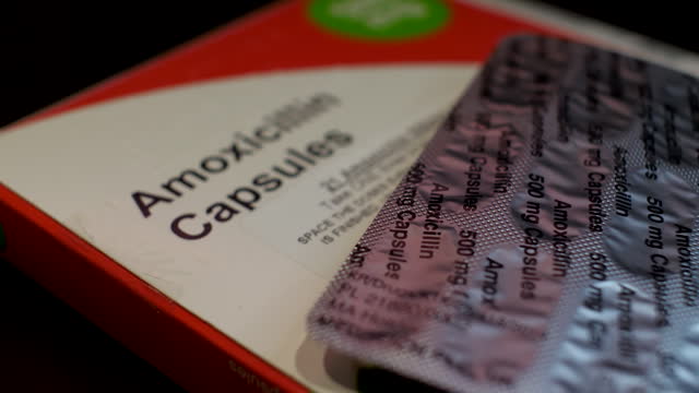 Close-up shot of Amoxicillin antibiotic medication in capsule form with packaging