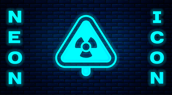 Glowing neon Triangle sign with radiation symbol icon isolated on brick wall background. Vector.