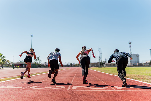 Athletes running on track and field stadium