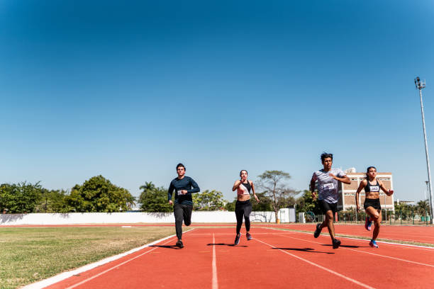 athletes running on track and field stadium - track and field 30s adult athlete photos et images de collection