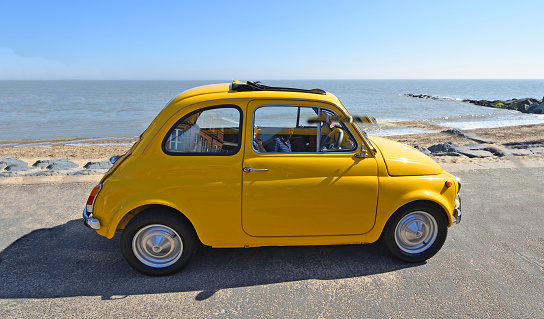 Felixstowe, Suffolk, England -  May 06, 2018: Classic  Yellow Fiat 500 parked on seafront promenade.