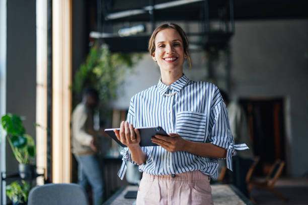 istock Confident Businesswoman Smiling with Digital Tablet in Office 2011075824
