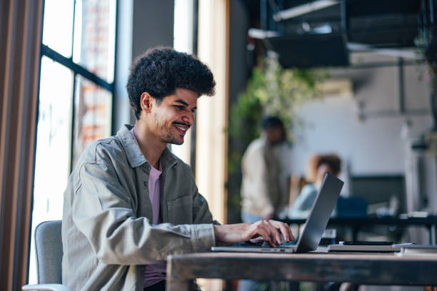 istock Smiling Young Man Working on Laptop in Modern Office 2011075852
