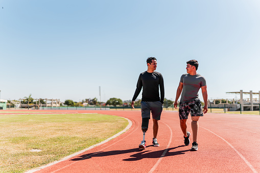 Athletes with artificial leg walking on sports track