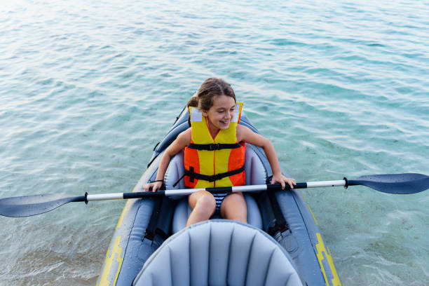 girl having fun with inflatable kayak on her summer cam vacation - summer camp child teenager kayak zdjęcia i obrazy z banku zdjęć