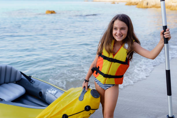 girl having fun with inflatable kayak on her summer cam vacation - summer camp child teenager kayak zdjęcia i obrazy z banku zdjęć